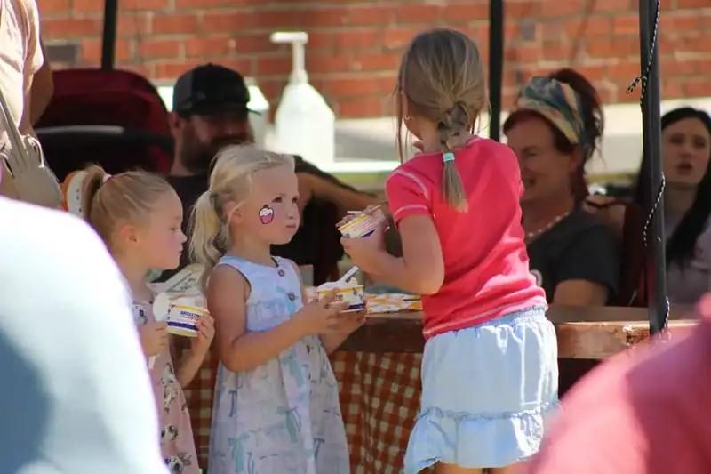 Children with cups of fresh-churned ice cream at the stand