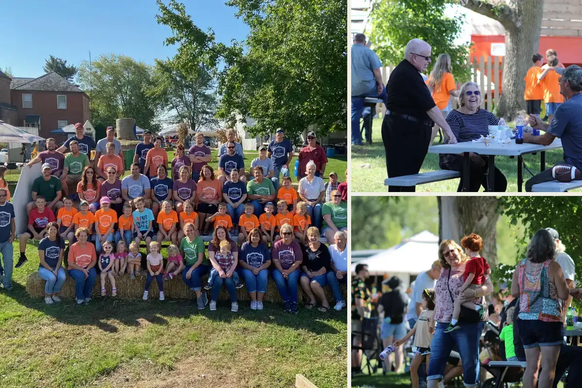Parish volunteers in festival shirts, visiting at the picnic tables, and the crowd under the trees